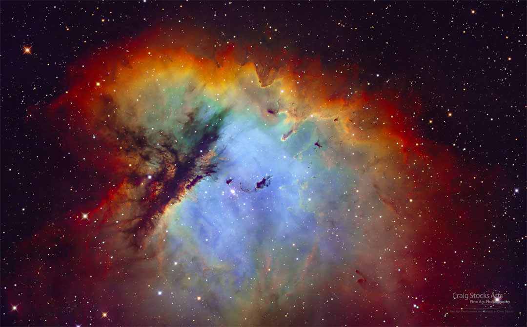 A nebula that appears blue in the middle and is surrounded by
red-glowing gas is featured. Dramatic lanes of dark dust cut
through the nebula's left side. A group of stars is visible toward
the nebula's centre.
Please see the explanation for more detailed information.