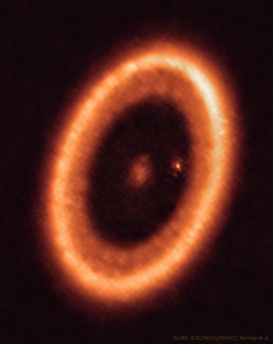 An orange elliptical ring is shown that is a disk of
gas and dust around the star PDS 70. In the centre of the disk
is a fuzzy spot and near the inner right edge of the disk is
another fuzzy spot. 
Please see the explanation for more detailed information.
