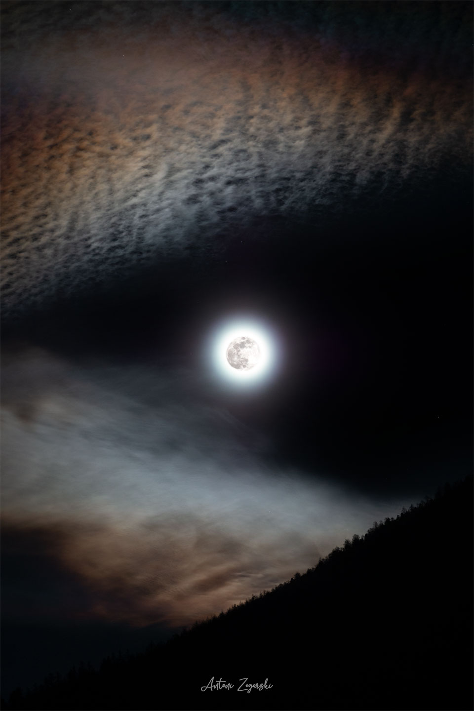 A bright full moon is seen in the centre of the
image. Angular clouds are seen around the edges which
make the moon look like it is either in the mouth
of the wolf, or the eye of a wolf. 
Please see the explanation for more detailed information.