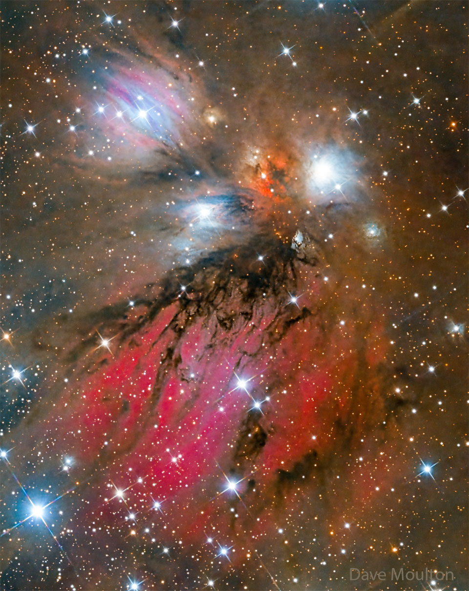 A complex jumble of colourful gas and dark dust
dominate a bright field of stars. 
Please see the explanation for more detailed information.