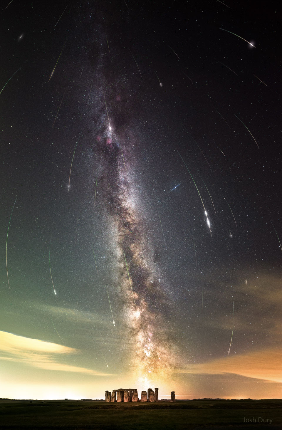 A night sky filled with stars and the band of our Milky
Way galaxy is shown also filled with many streaks. The short
streaks are all coordinated and together indicate a flow
from the top of the image to the bottom. In the foreground
at the bottom of the frame is Stonehenge.
Please see the explanation for more detailed information.