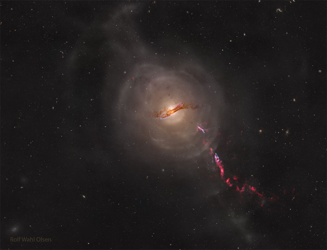 A galaxy is seen in the centre of the image. Faint shells are 
seen around it. A red-coloured jet is seen emanating from the galaxy 
toward the lower right. 
Please see the explanation for more detailed information.