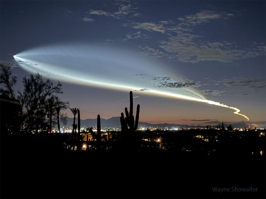 A horizon including the Tucson skyline and Saguaro cacti 
shows the sky just after sunset. Prominent in the sky are 
clouds oddly shaped like a fish -- but are the launch plume
of a recently launched rocket from California.
Please see the explanation for more detailed information.