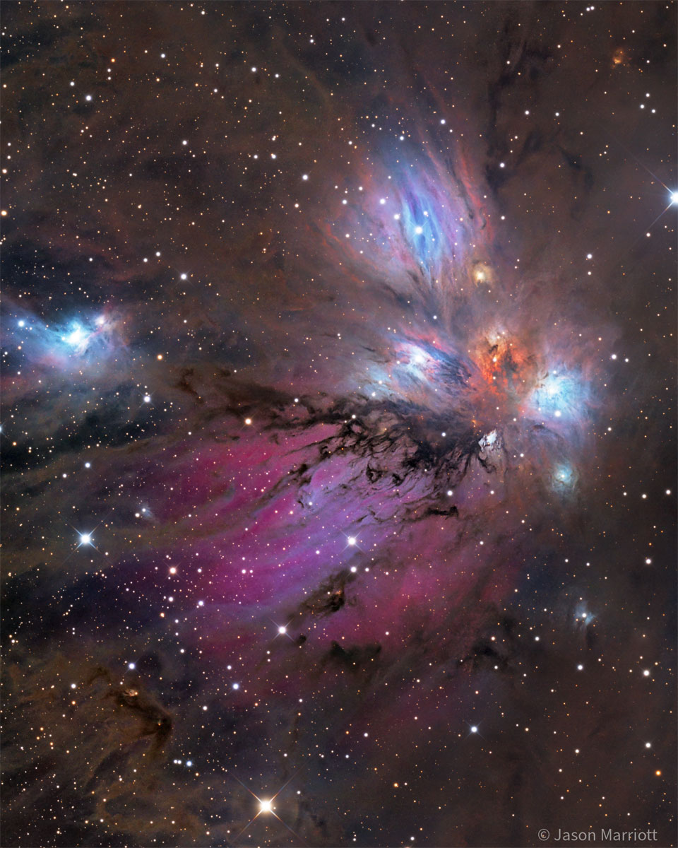 A starfield surrounds a colourful nebula that
glows both red and blue but is filled with dust, both 
light brown and dark brown. 
Please see the explanation for more detailed information.