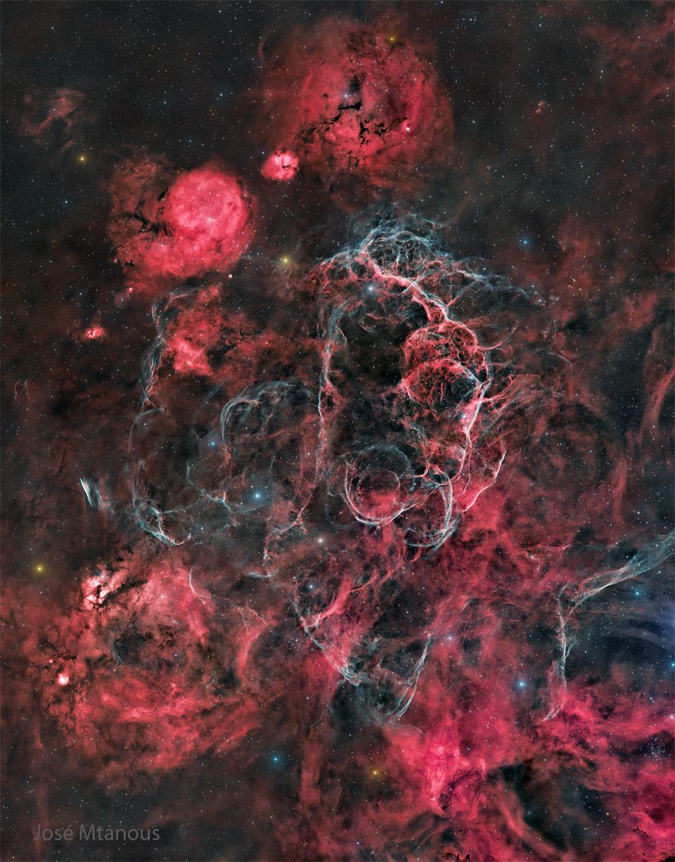The starfield is filled with many red nebulae, areas
of dark dust, and light blue filaments. 
Please see the explanation for more detailed information.
