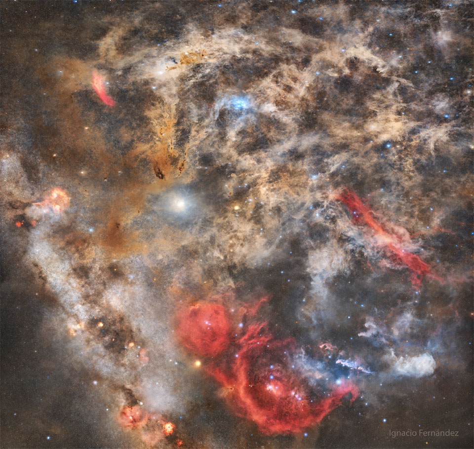 The featured image shows a dusty starfield with intricate
dust filaments all over. Red, blue, and brown nebulae will the 
field. 
Please see the explanation for more detailed information.