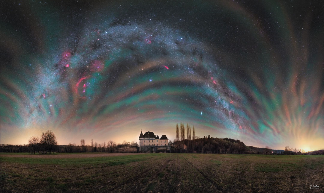The sky over a picturesque chateau in France is shown featuring
colourful airglow all around. Identifiable in the background night sky 
are objects that include the Orion Nebula, Sirius, Mars, and an 
arching band of our Milky Way Galaxy.
Please see the explanation for more detailed information.