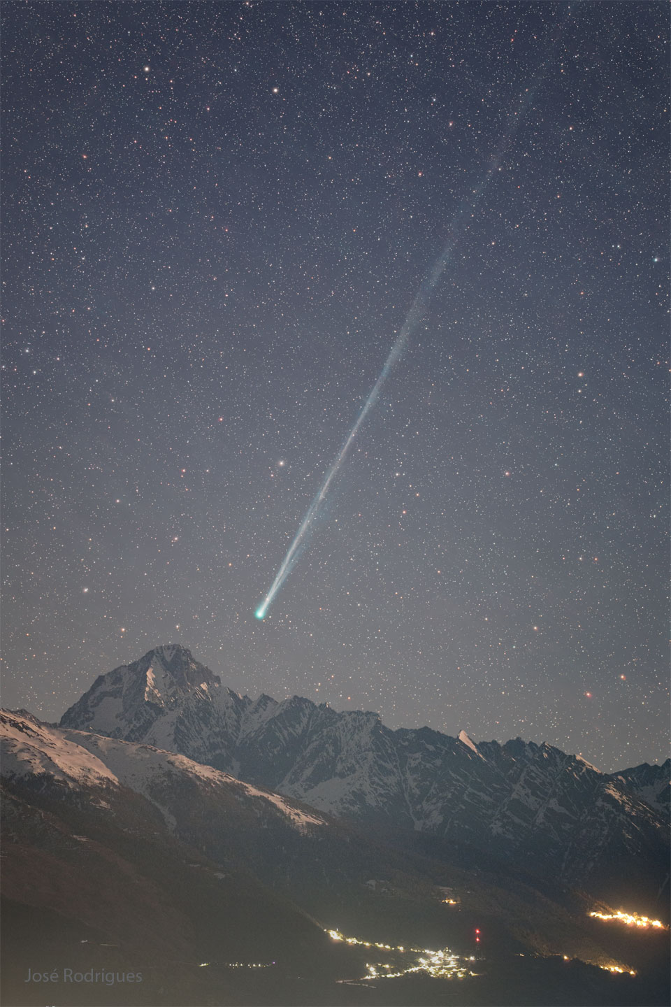 A starry night is seen above foreground mountains. Toward
 the right is a comet with its head near the bottom centre
and a long tail extending toward the upper right. 
Please see the explanation for more detailed information.