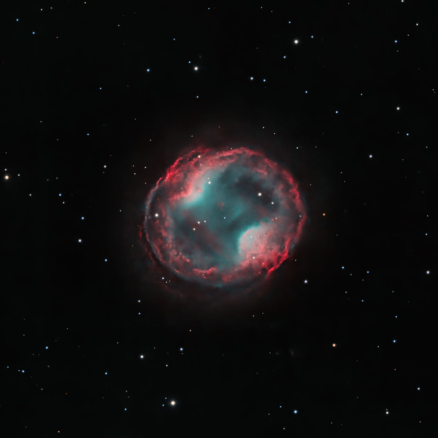 A bubble of gas occupies the centre of the image with a few stars in the fore- and background. On opposite sides of the bubble, there are two 
regions where the gas pinches inward. This makes the inner region of the nebula appear like a peanut inside a larger ring.